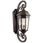 The Courtyard(TM) 40.50in; 3 light outdoor wall light with clear seeded glass Rubbed Bronze finish. The Courtyard wall light curls and heritage detail give a distinguished traditional look.
